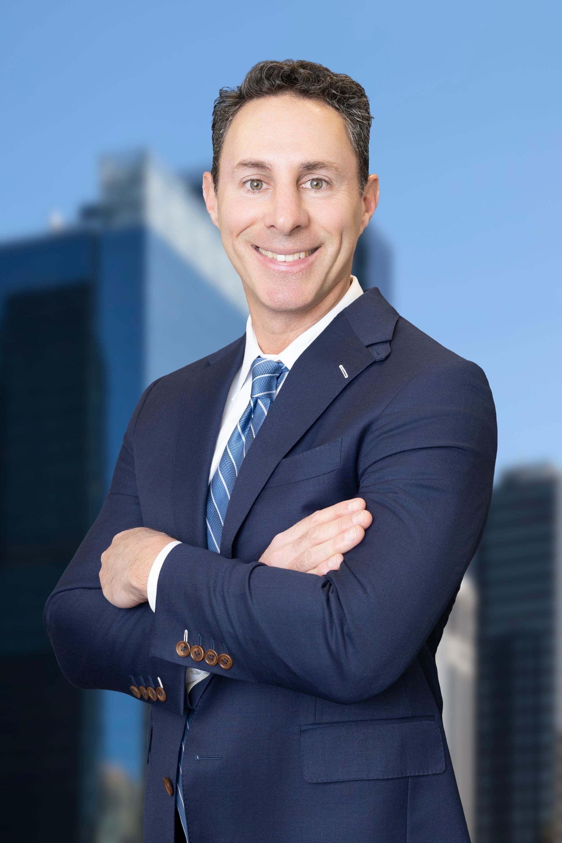 A man in a suit and tie is smiling for the camera