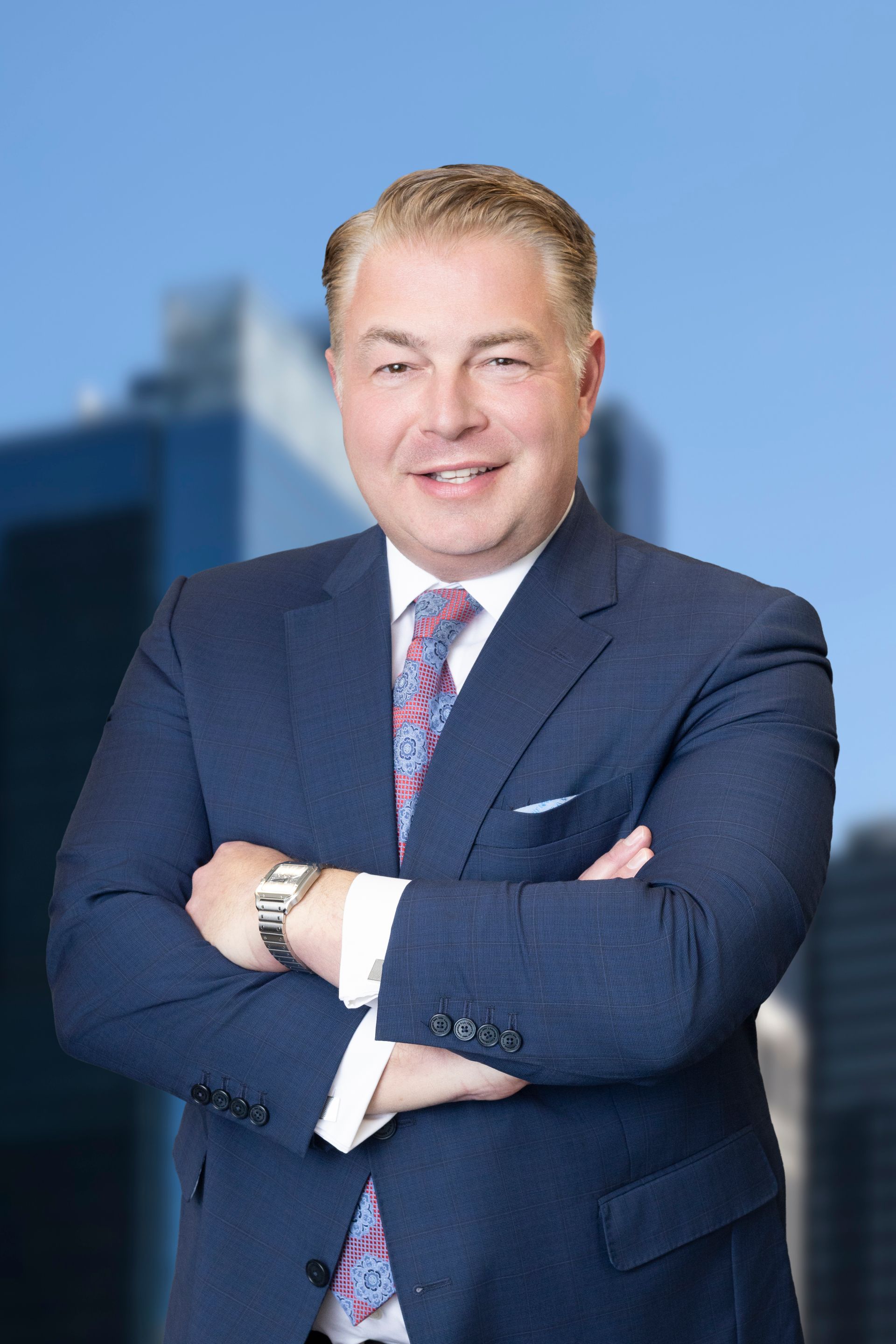 A man in a suit and tie is smiling for the camera
