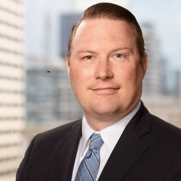 A man in a suit and tie is smiling for the camera
