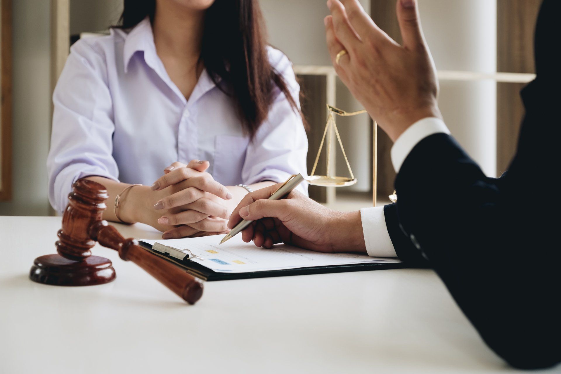 A woman is sitting at a table talking to a lawyer.