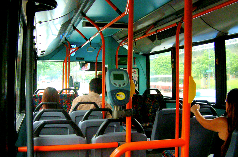 The inside of a bus with people sitting on it