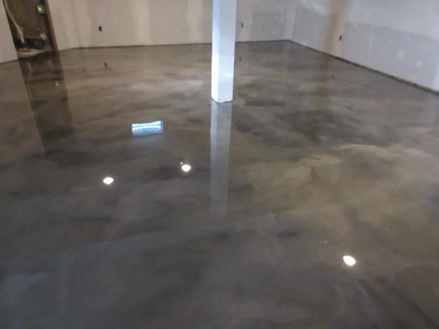 Polished concrete floor in an empty room, reflecting light and a white column
