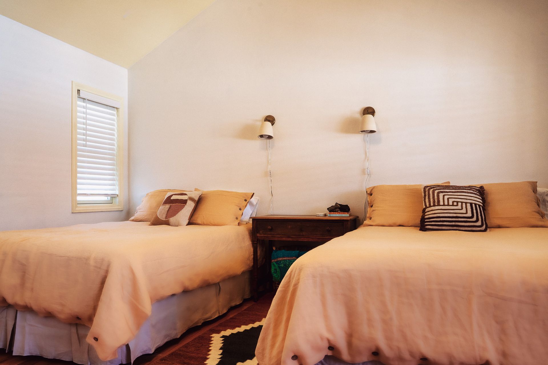 A bedroom with two beds and a window