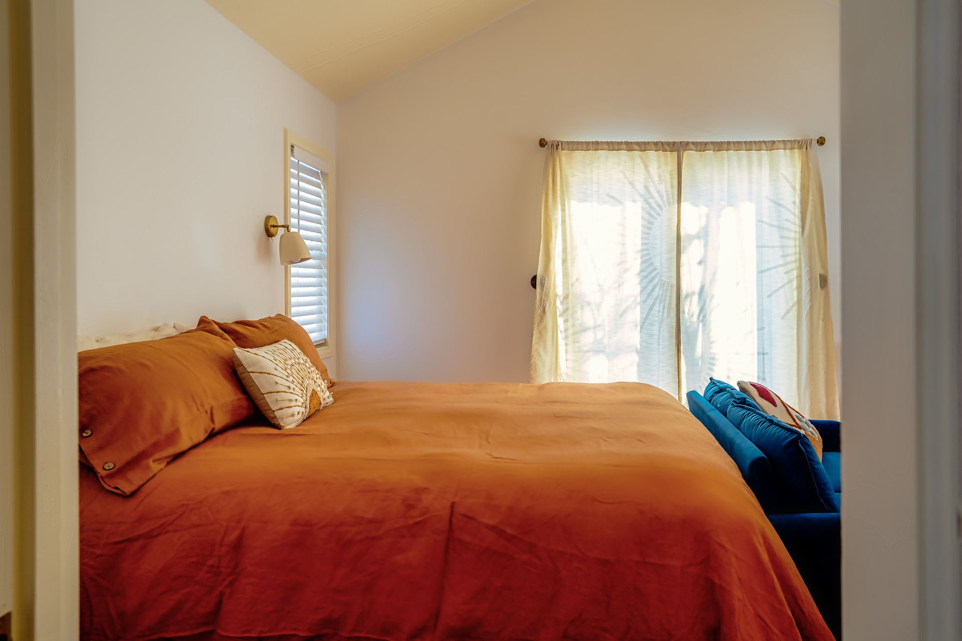 A bedroom with a bed , couch , and window.