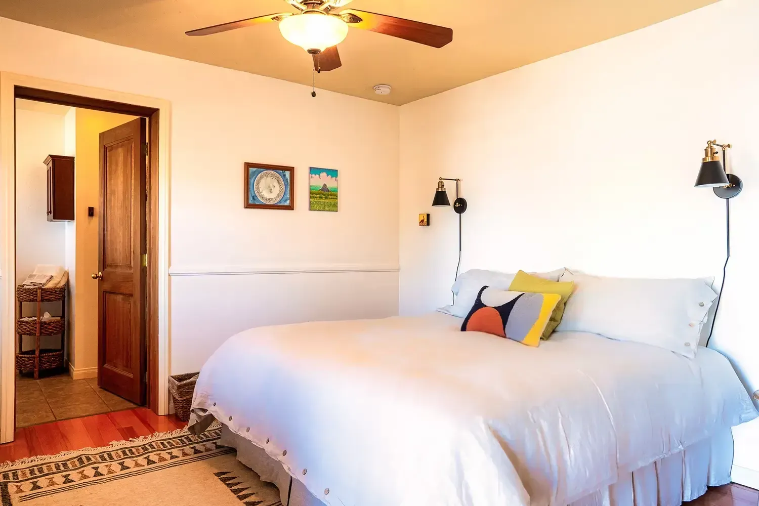 A bedroom with a large bed and a ceiling fan.