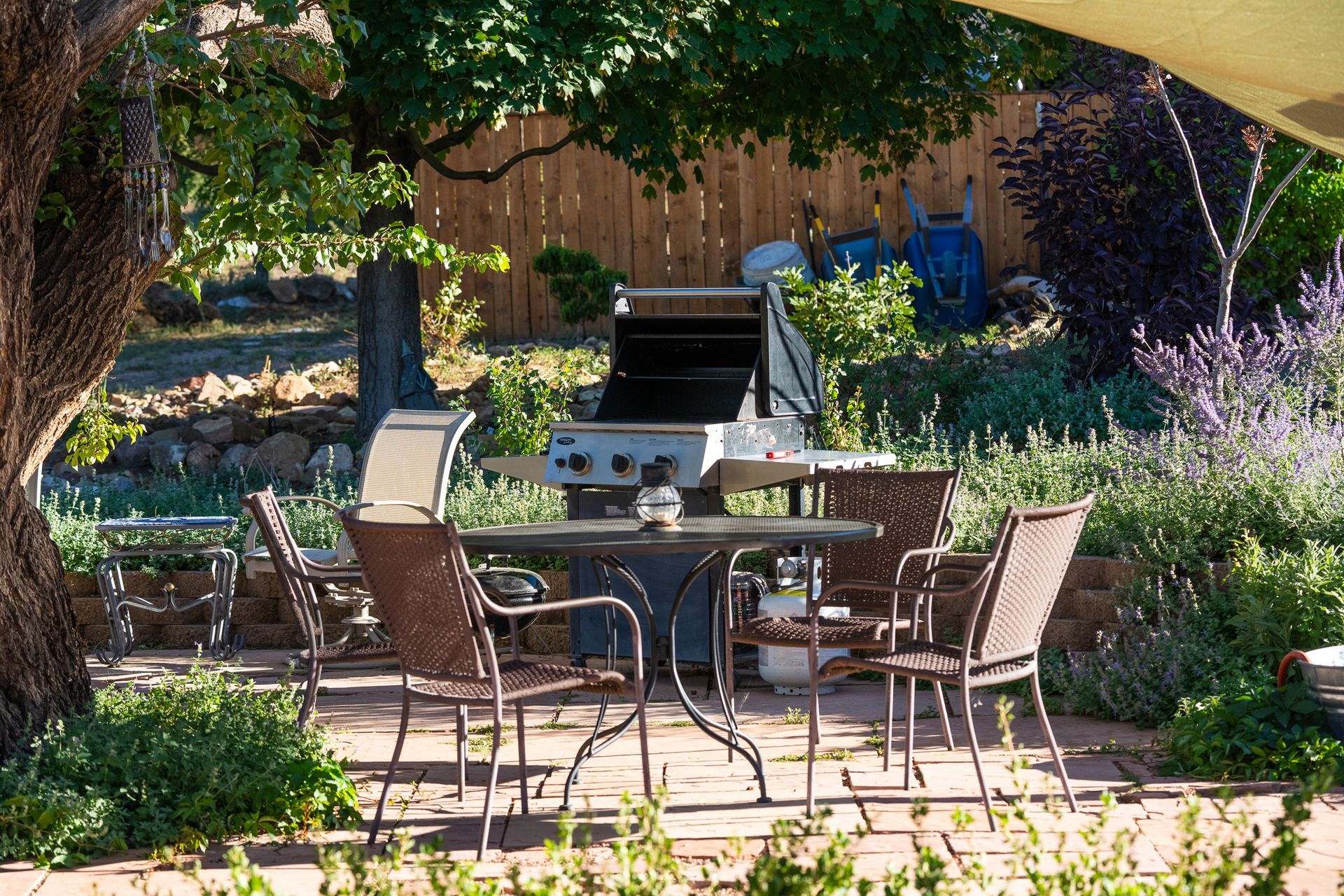 A patio with a table and chairs and a grill