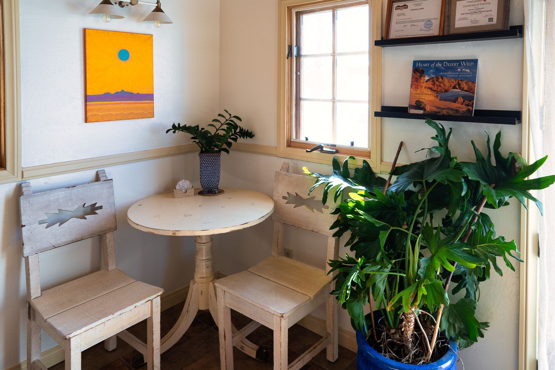 A room with a table and chairs and a potted plant