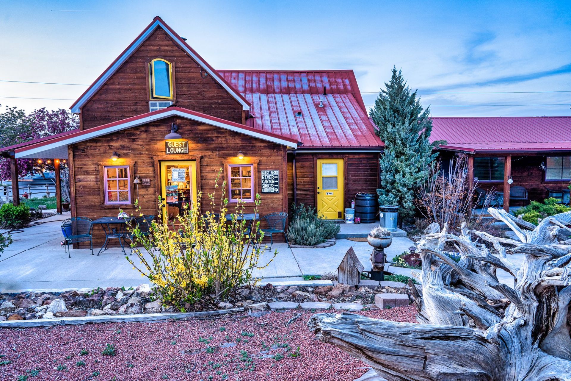 A large wooden house with a red roof and a yellow door.