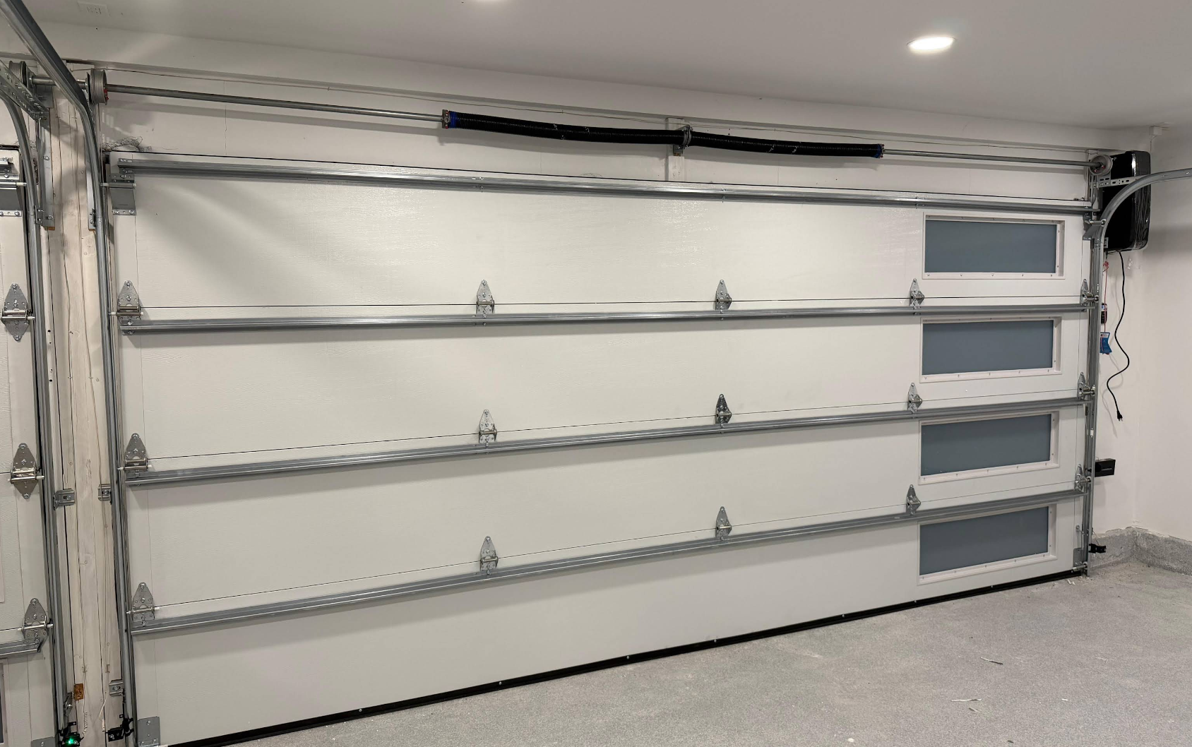 Large white wall-mounted shelving unit in a bright room, with metal support brackets and a few small items.