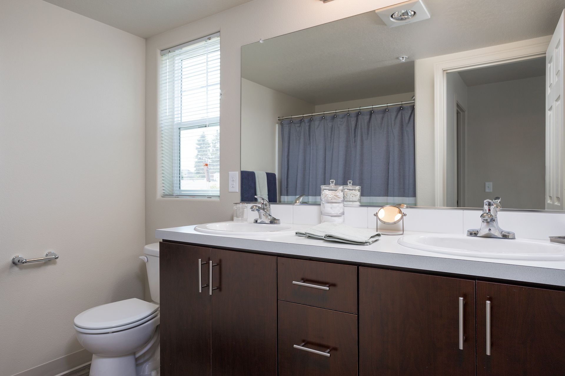 A bathroom with a toilet , sink and mirror