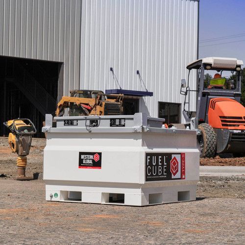 Gray fuel cube tank on a construction site beside a forklift and warehouse
