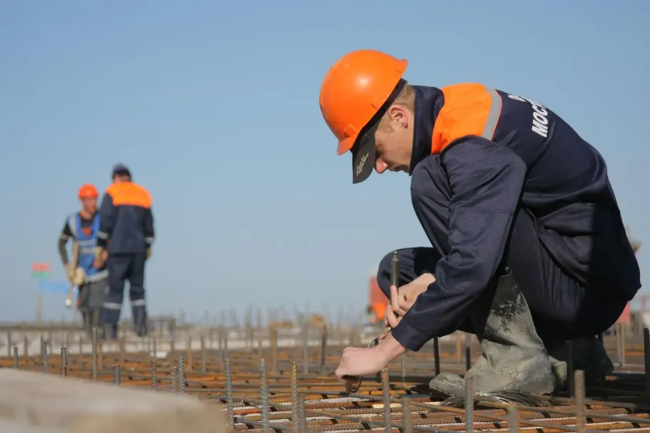 Construction worker tying rebar on a building foundation.