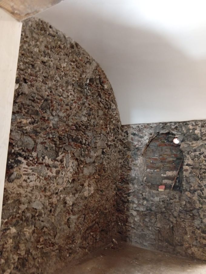 Interno con pareti in pietra, soffitto a volta e piccole aperture finestrate.
