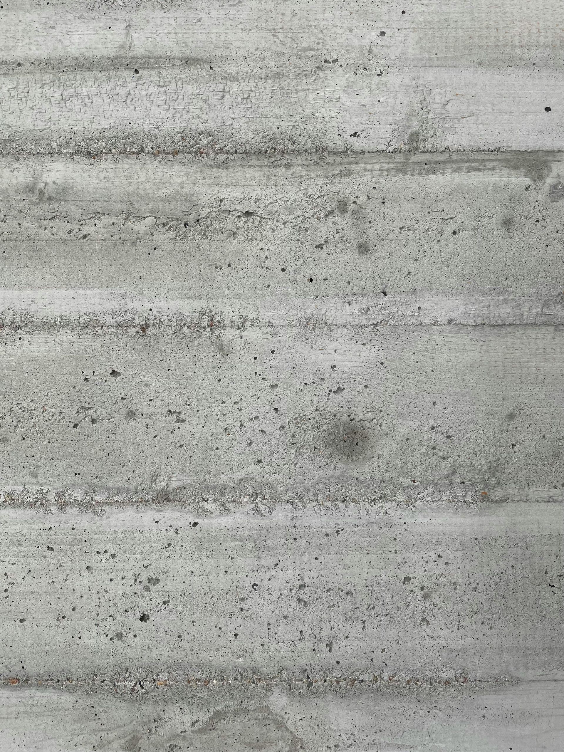 A wet concrete saw on a tiled floor during a renovation, with concrete dust and a shovel nearby.