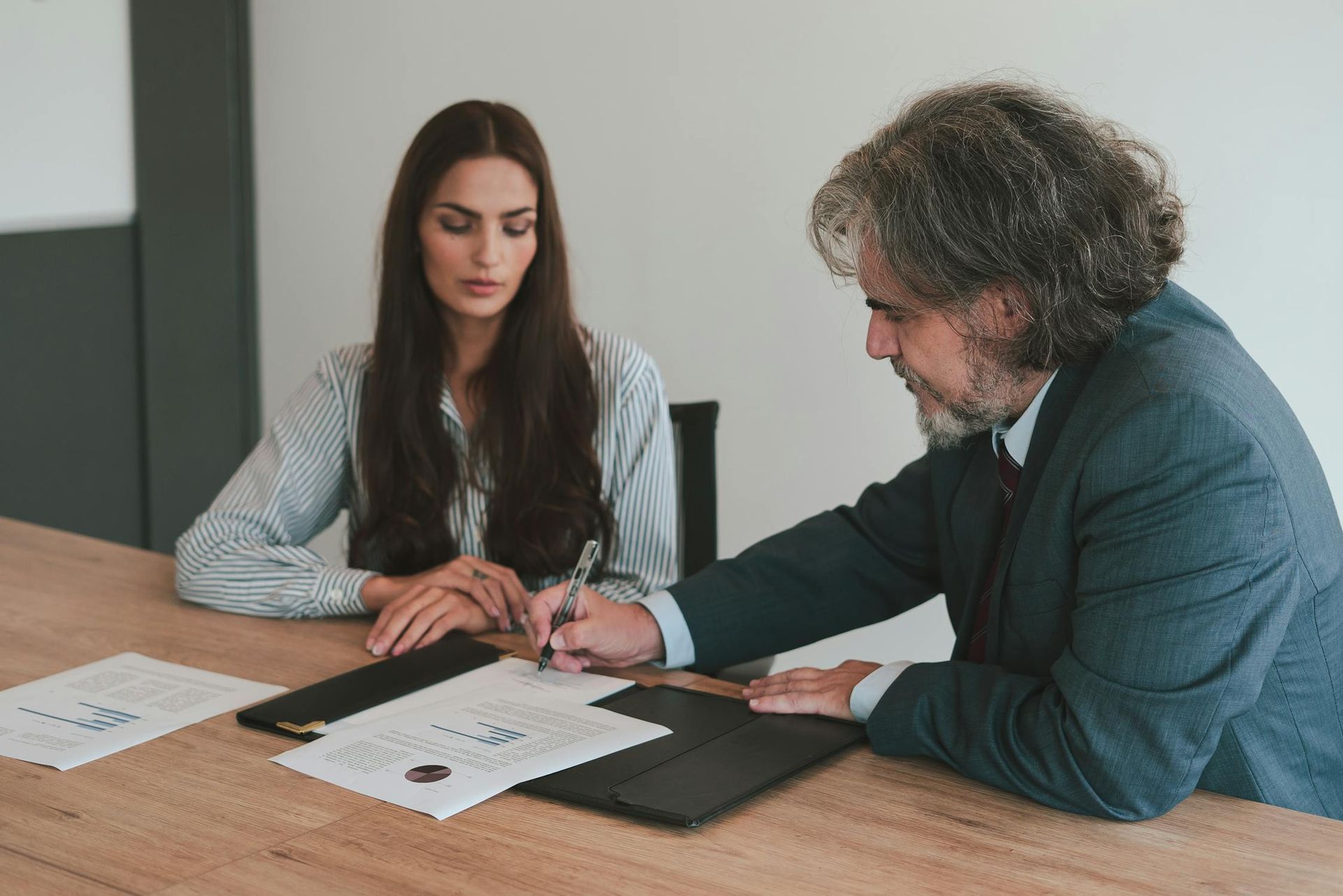 A businesswoman and a legal or financial advisor reviewing and signing Employee Stock Ownership Plan