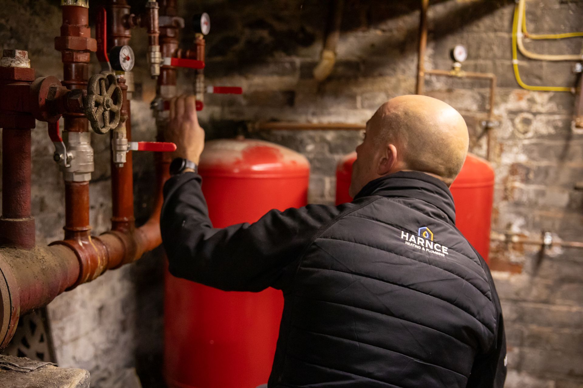 Man checking over boiler pipes in a basement