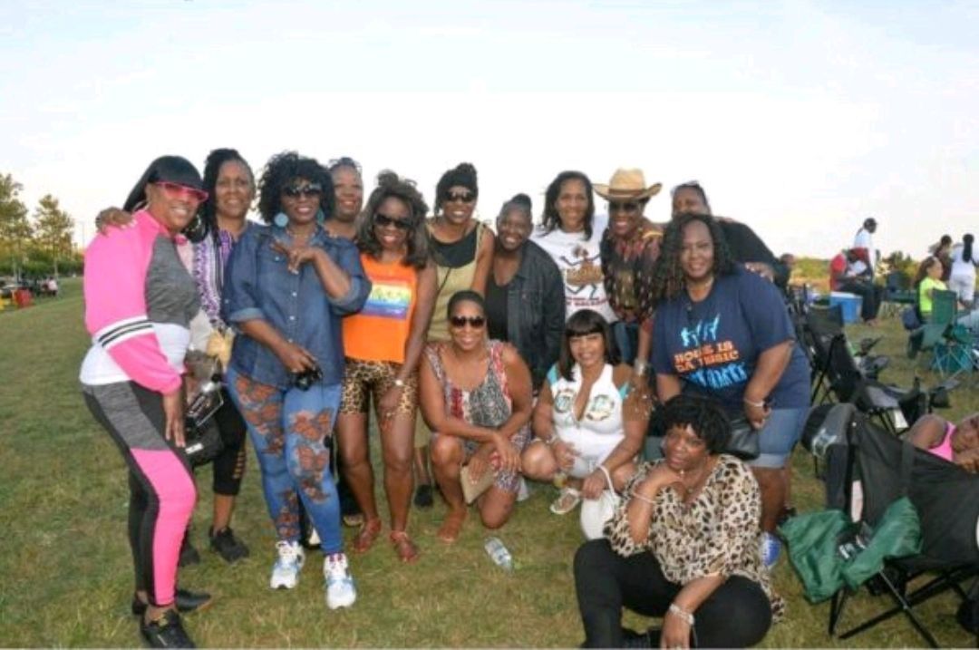 A group of women are posing for a picture in a field.