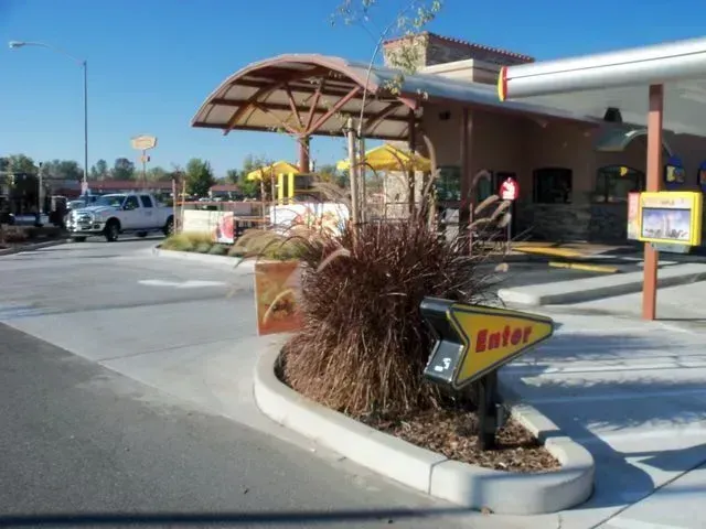 BMO bank branch on a tree-lined street, with brown exterior and red logo sign