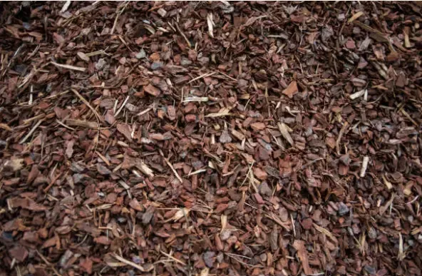 Pile of brown mulch and wood chips covering the ground