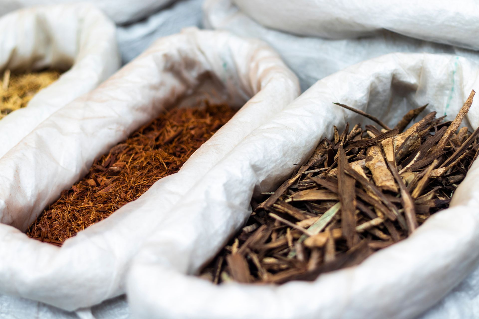 Open sacks of dried herbs and bark at a market stall