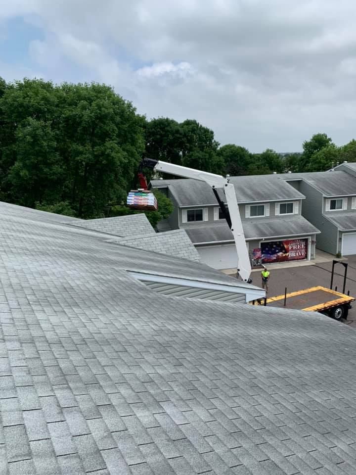 A crane is sitting on top of a roof of a house.