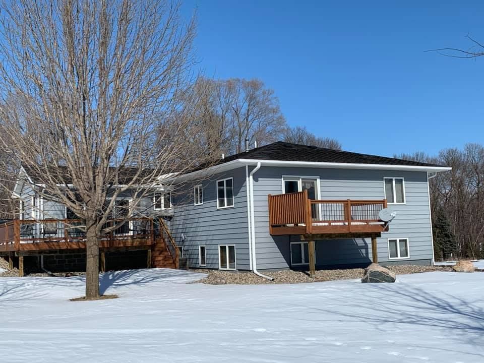 A large house with a large deck in the snow.