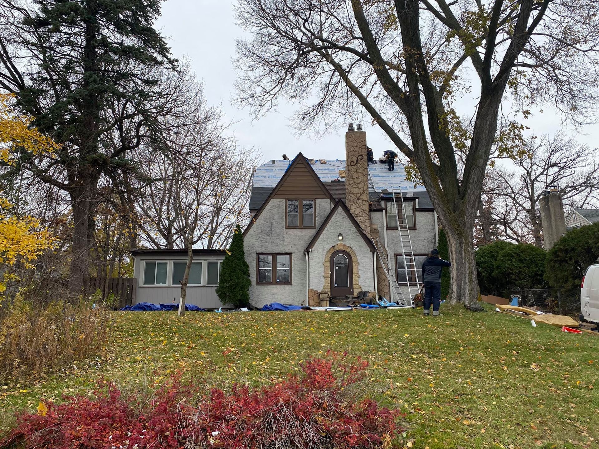 A large house is sitting on top of a lush green hill.