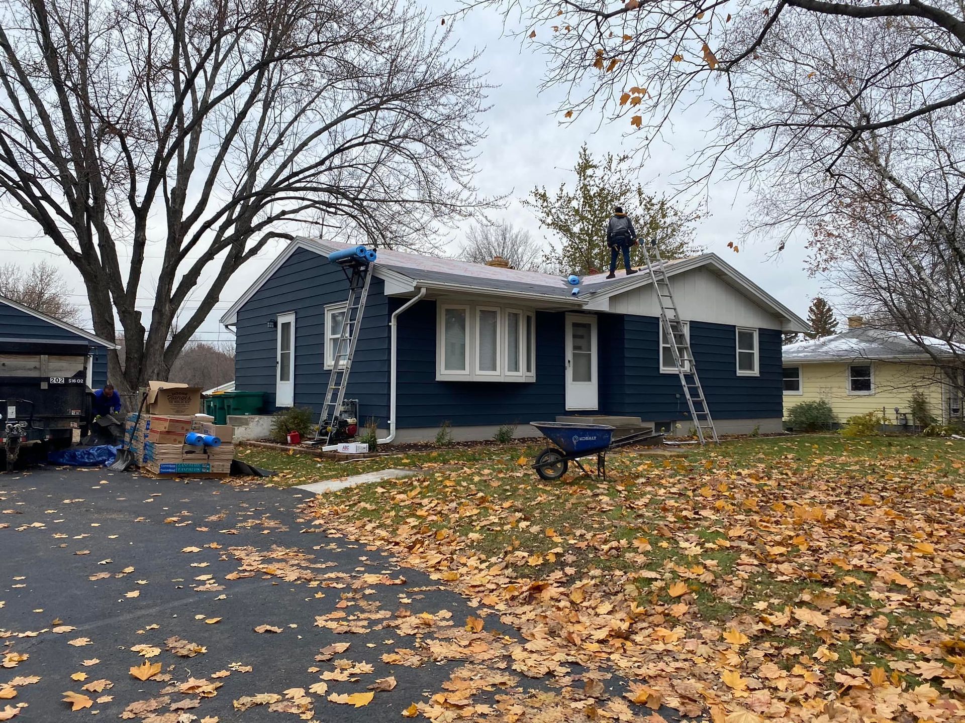 A man is standing on the roof of a house.