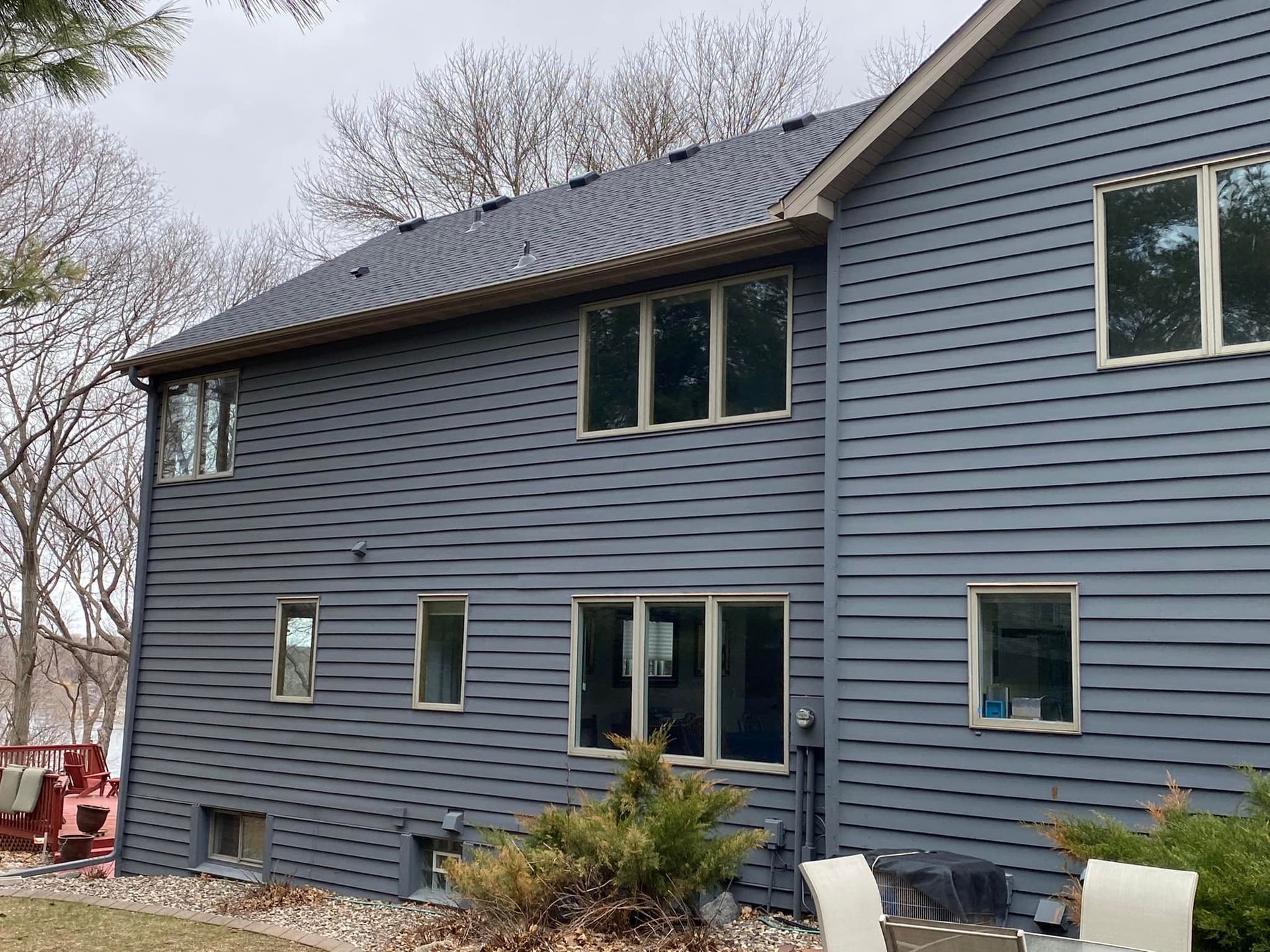 A large blue house with a lot of windows and a roof.