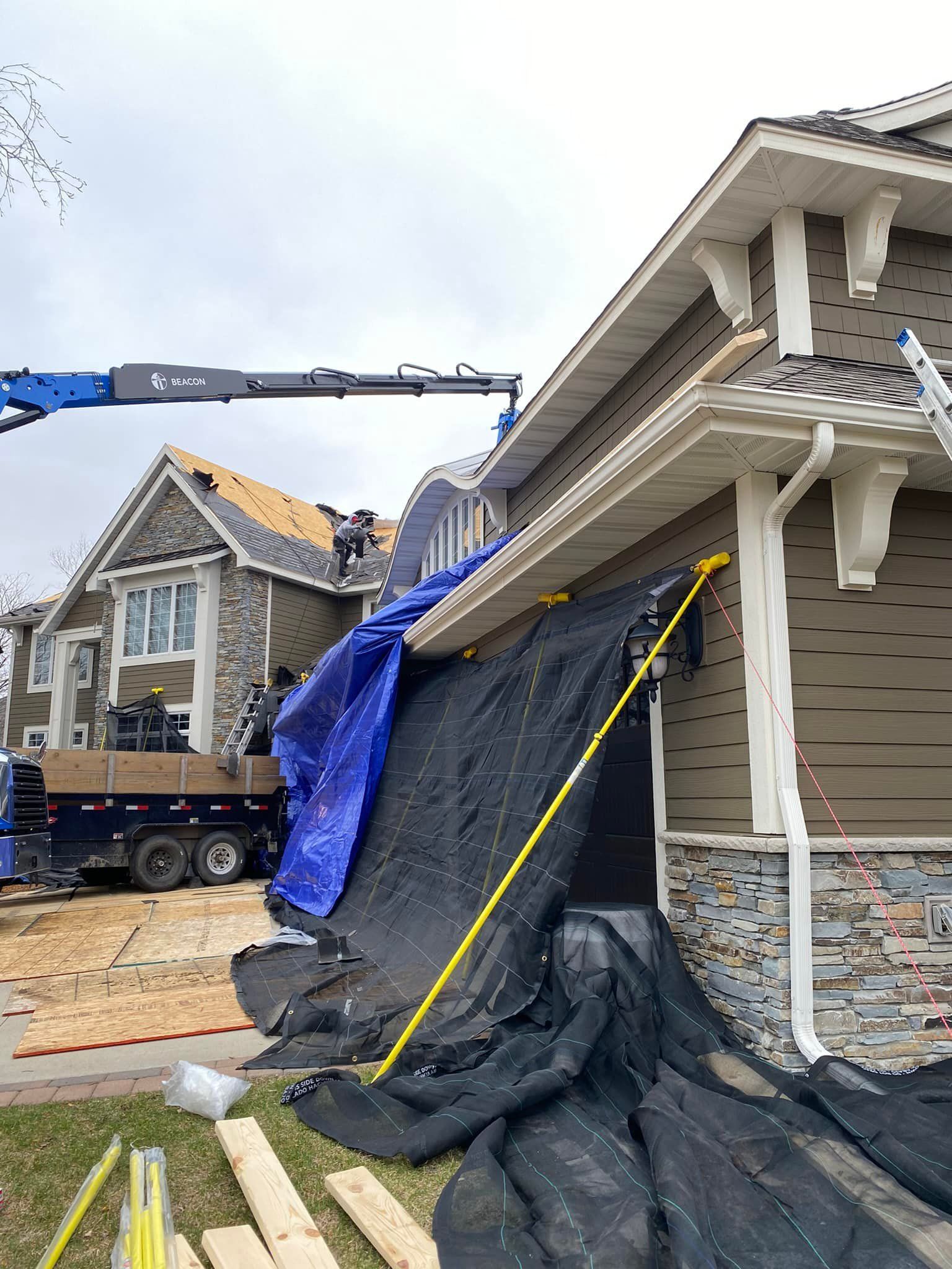 A crane is being used to install a roof on a house.