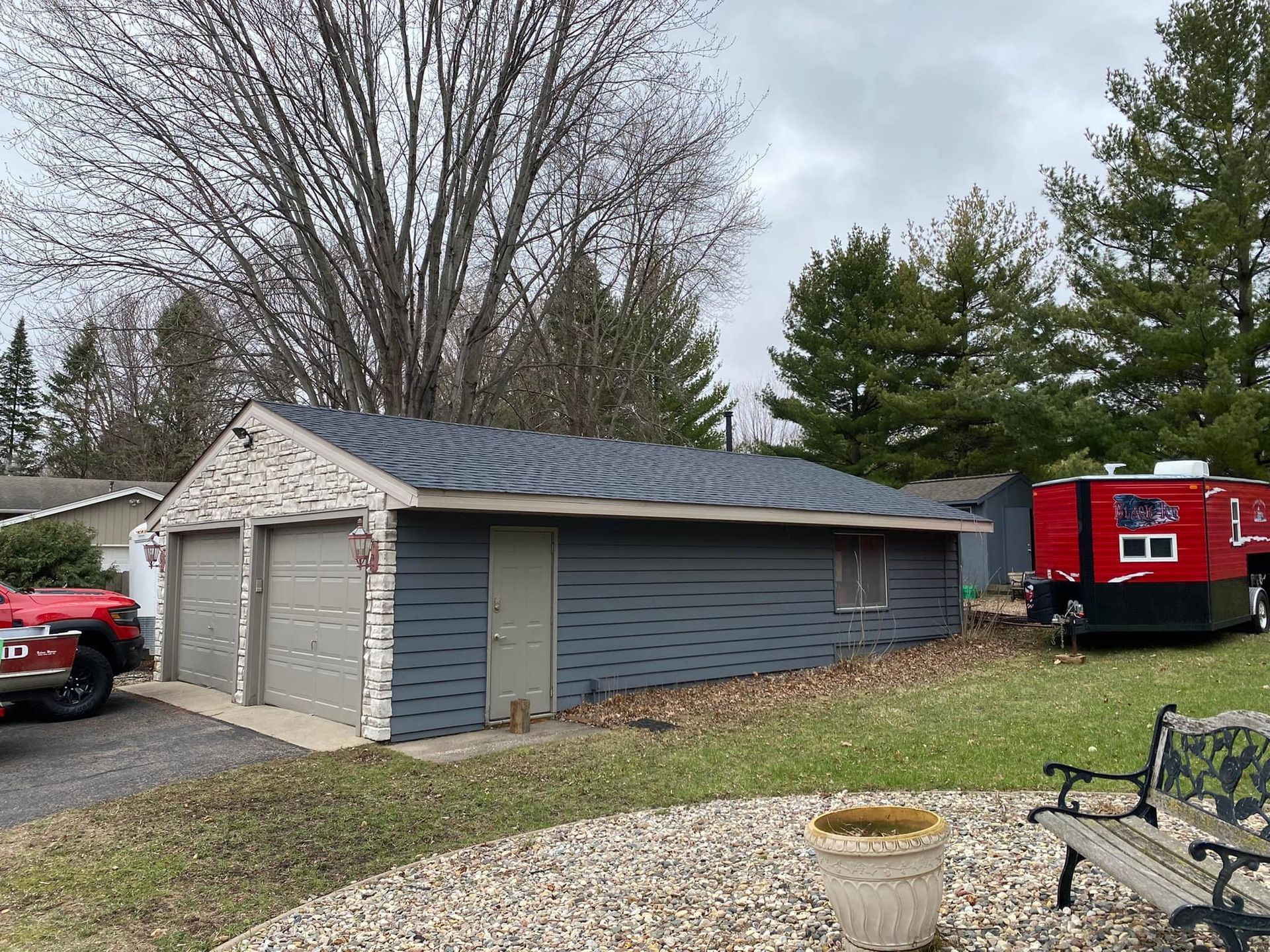 A red truck is parked in front of a garage.