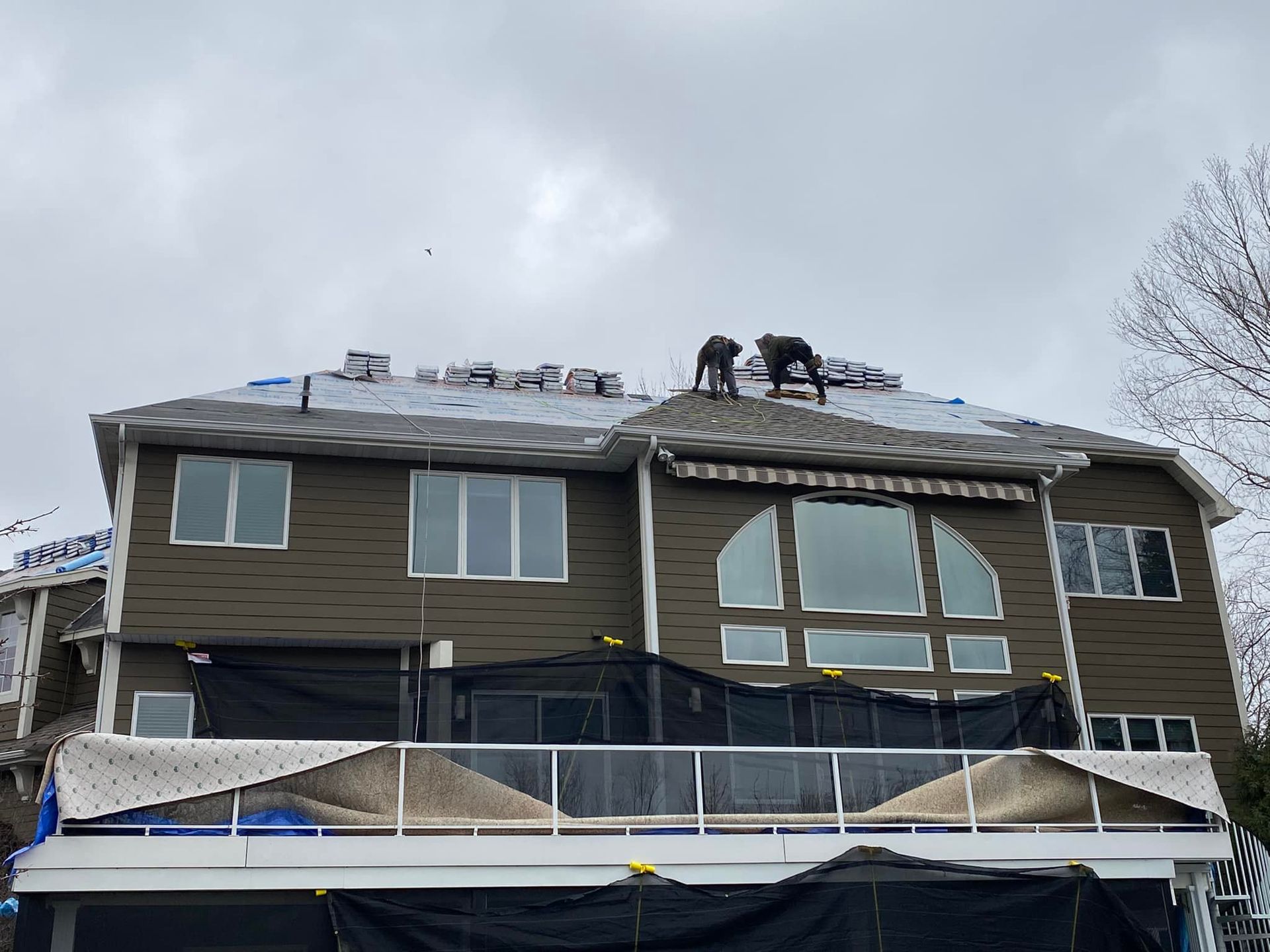 A large house with a balcony and a roof is being remodeled.