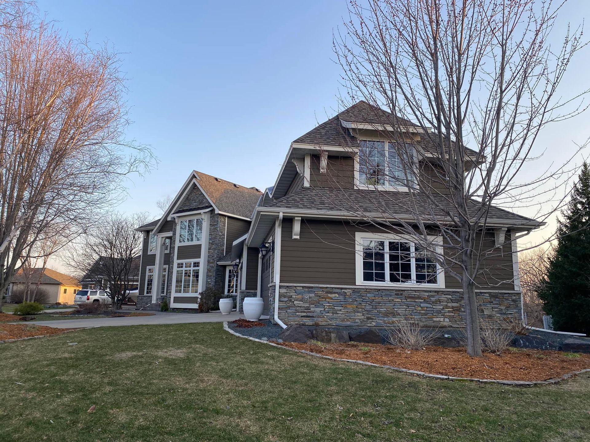 A large house with a lot of windows is sitting on top of a lush green lawn.