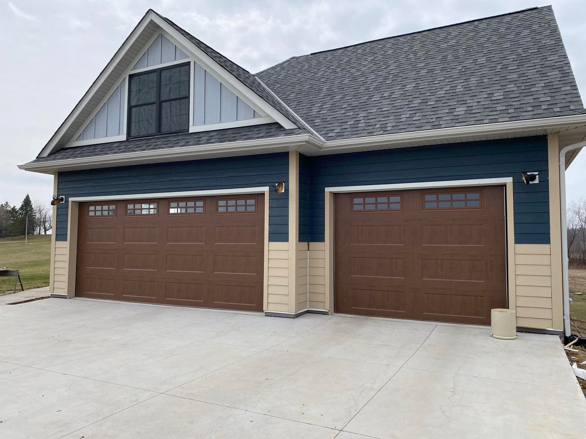 A house with two brown garage doors and a gray roof.