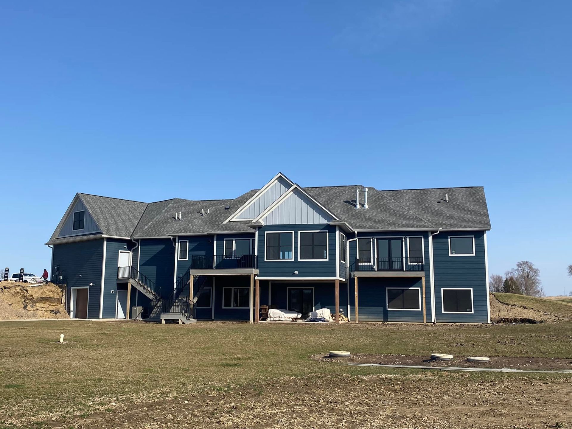 A large house is sitting in the middle of a grassy field.