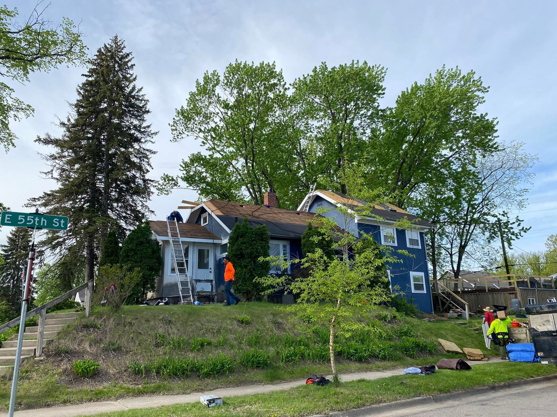 A blue house is sitting on top of a grassy hill.