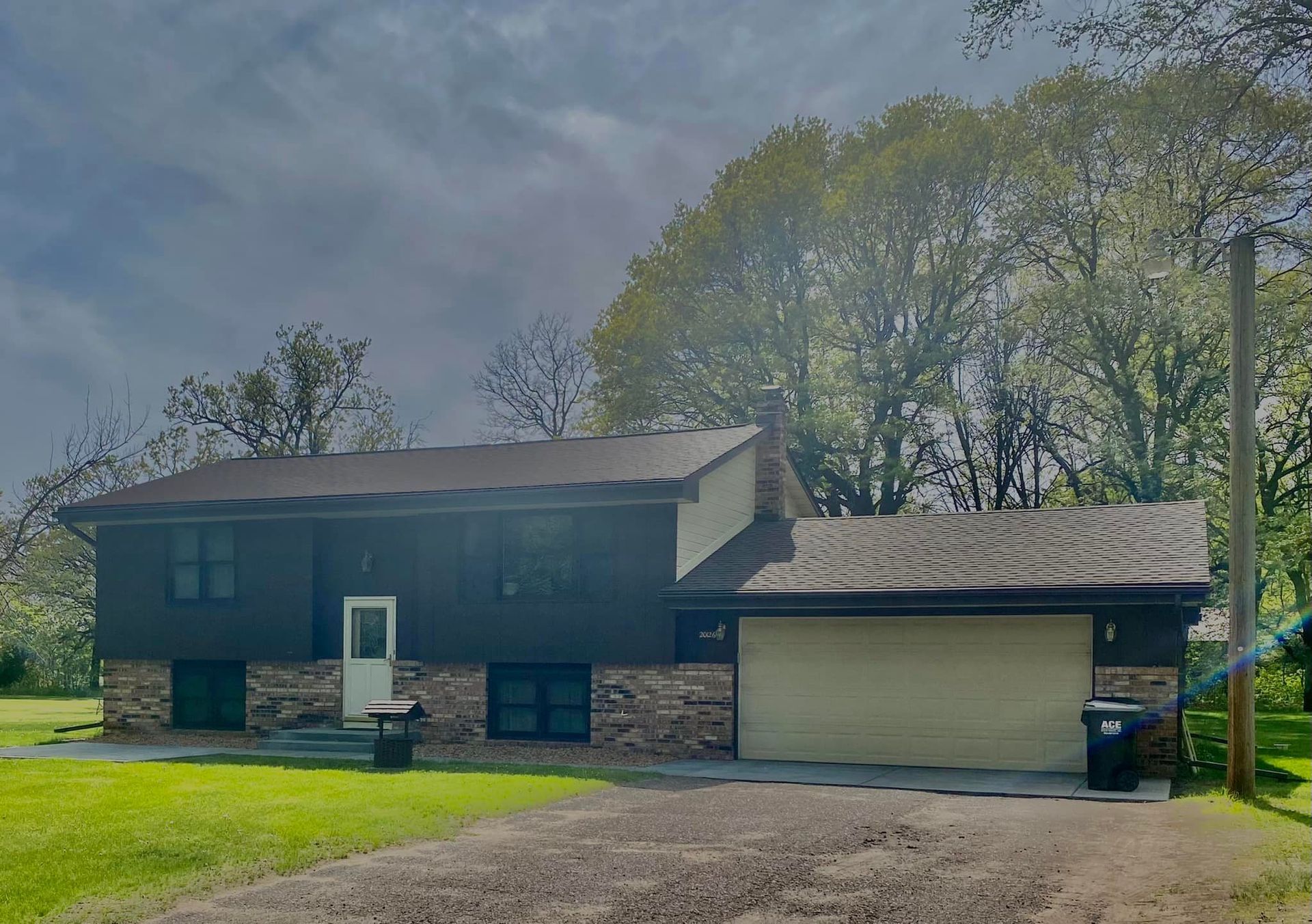 A house with a garage and trees in the background