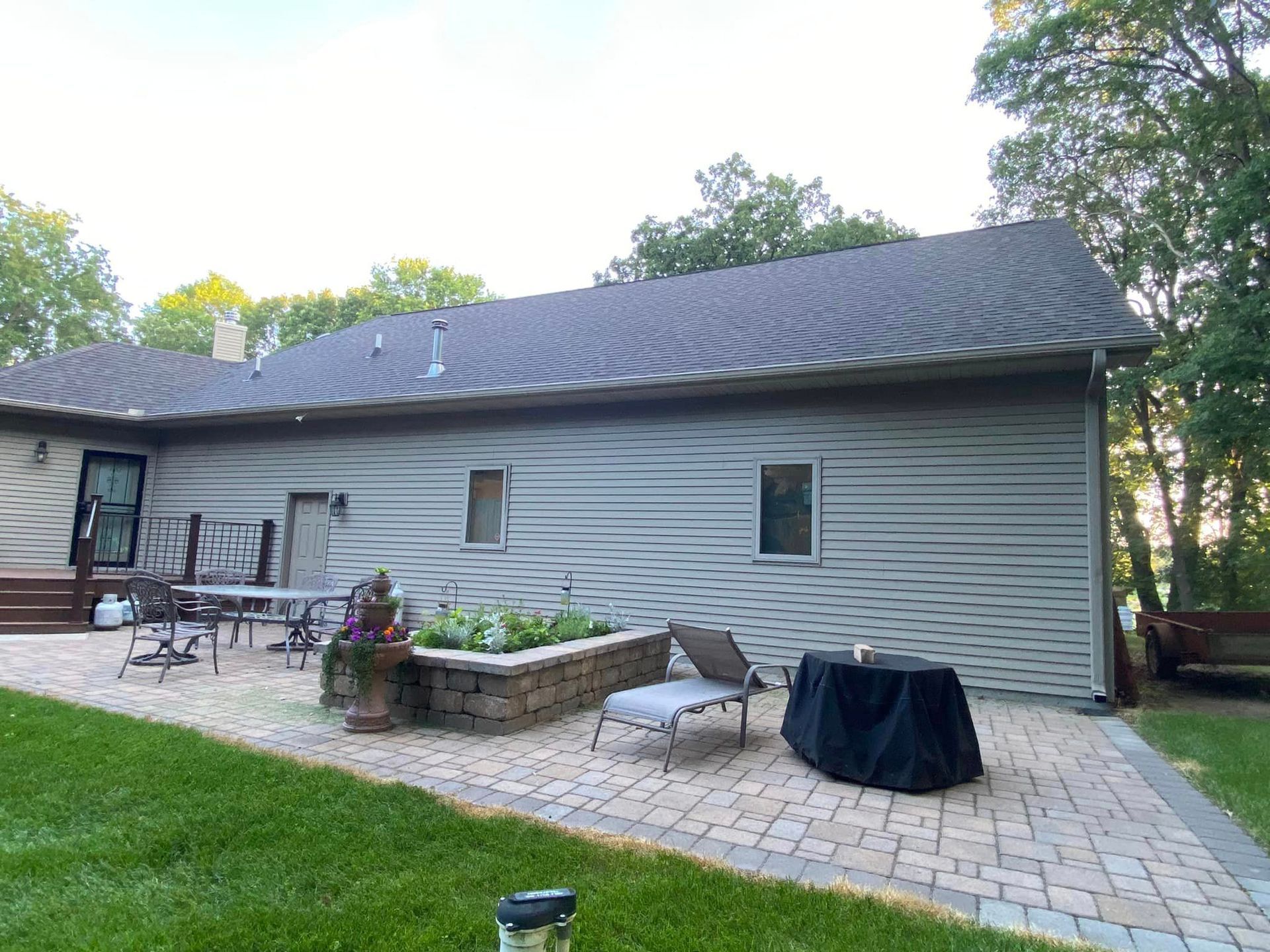 A house with a patio and a table and chairs in front of it.