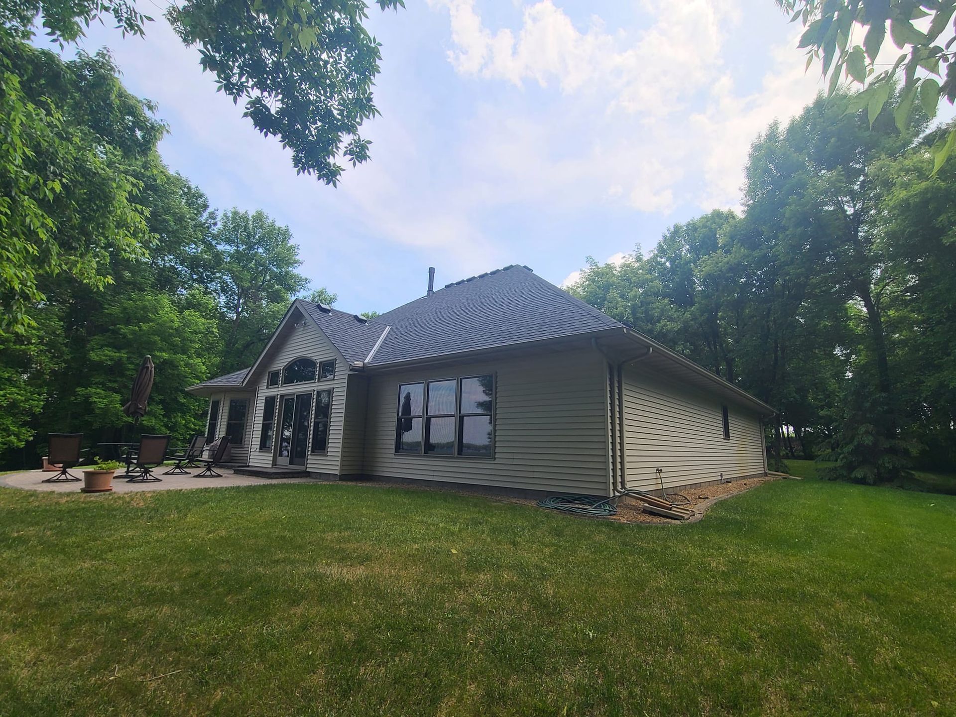 A large house with a lot of windows is surrounded by trees and grass.