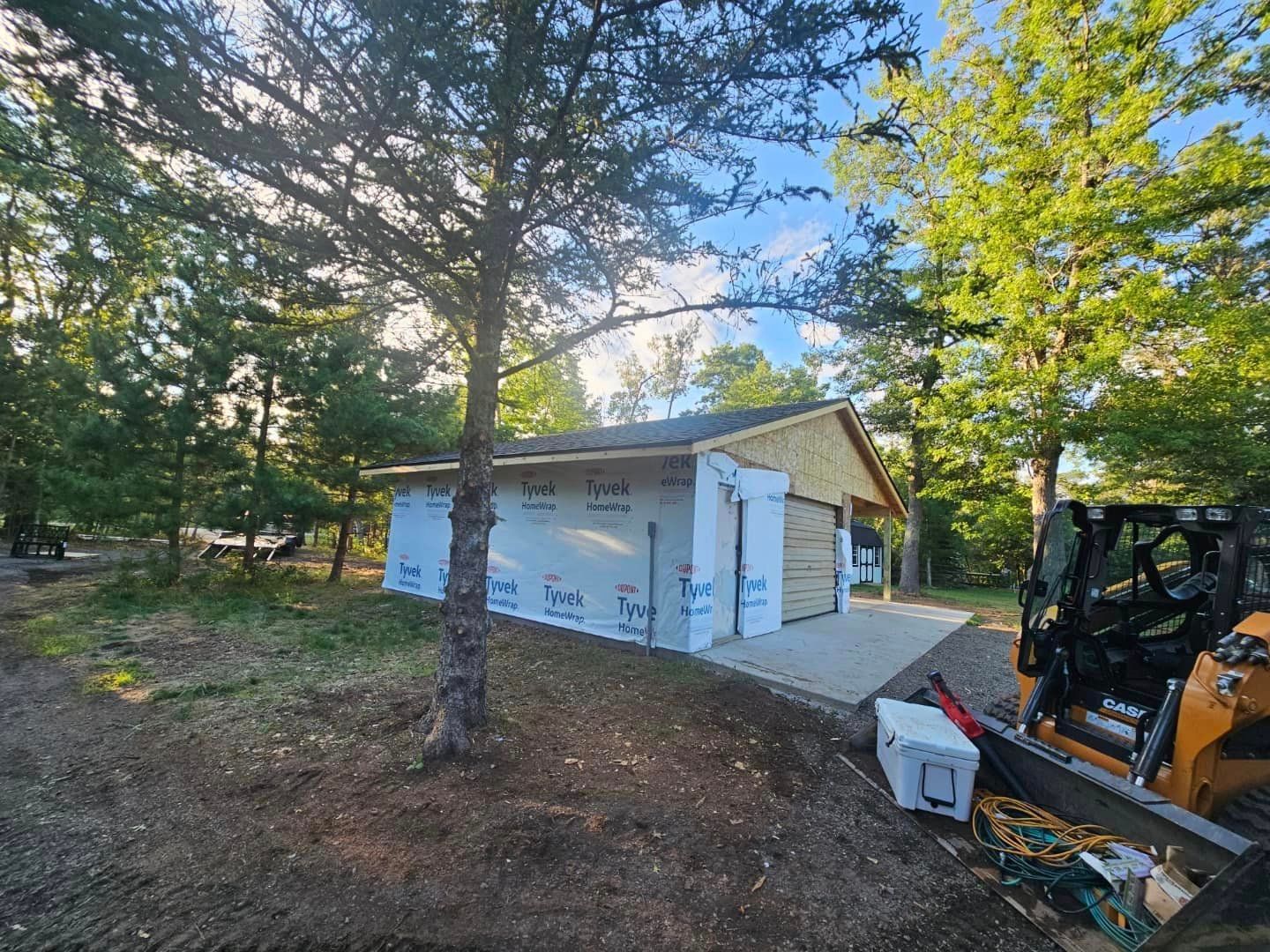 A forklift is parked in front of a garage under construction.
