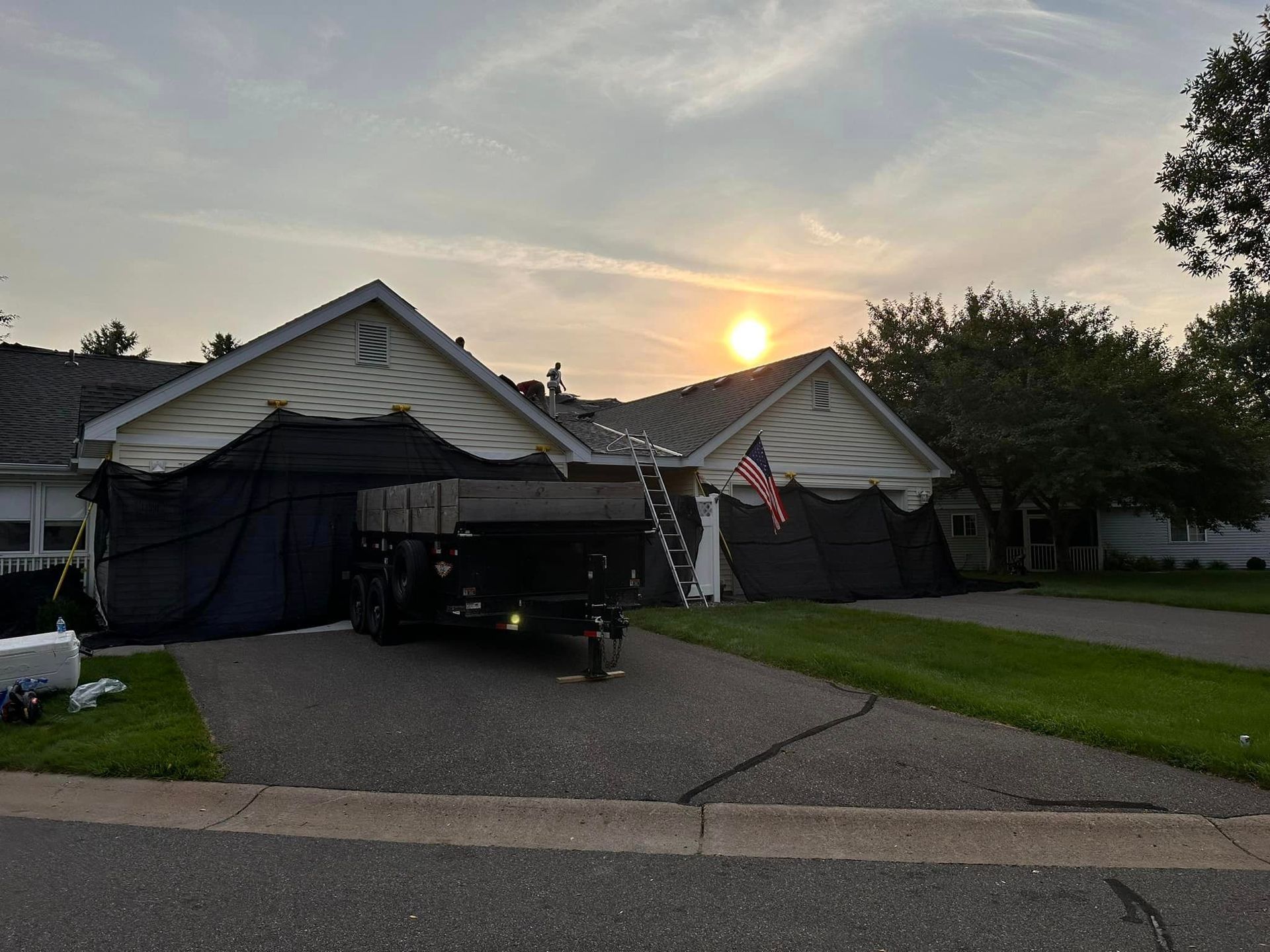 A truck is parked in front of a house with a tarp on the roof.