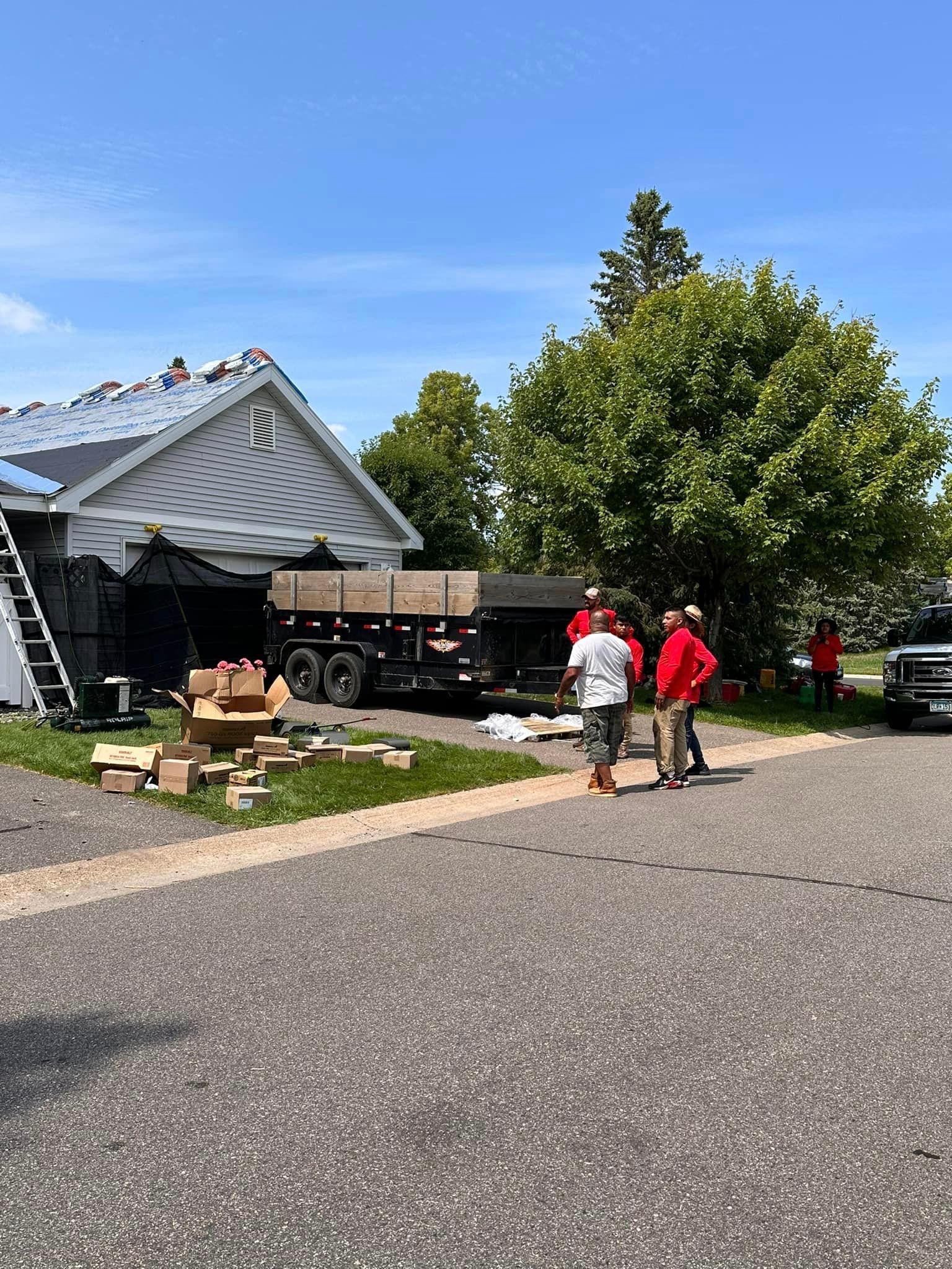 A group of people are standing in front of a house that is being remodeled.