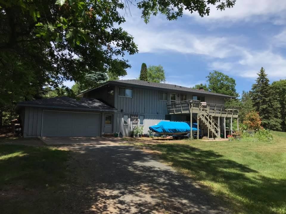 A large house with a blue boat parked in front of it