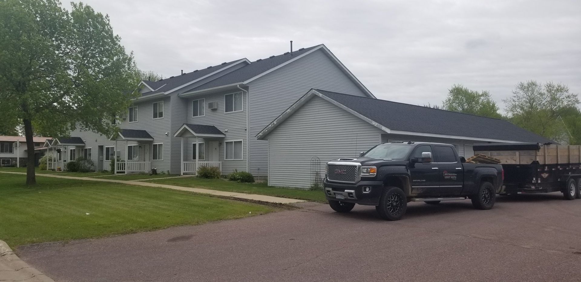 Two trucks are parked in front of a house.