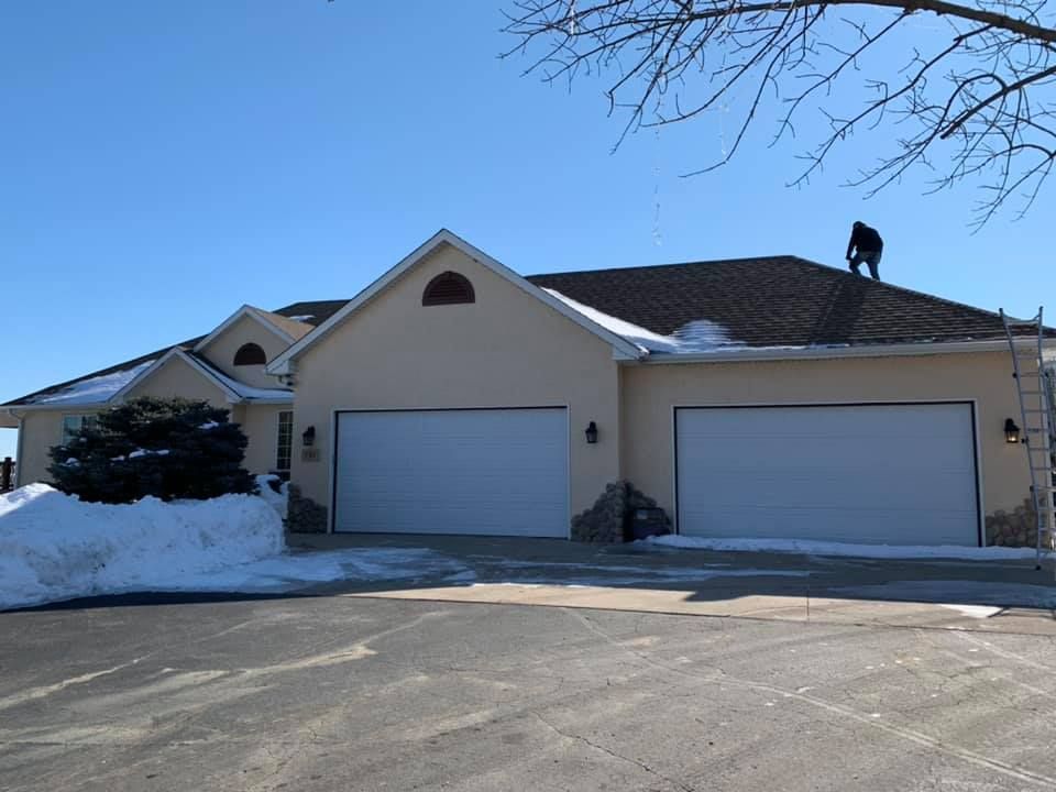 A man is standing on the roof of a house