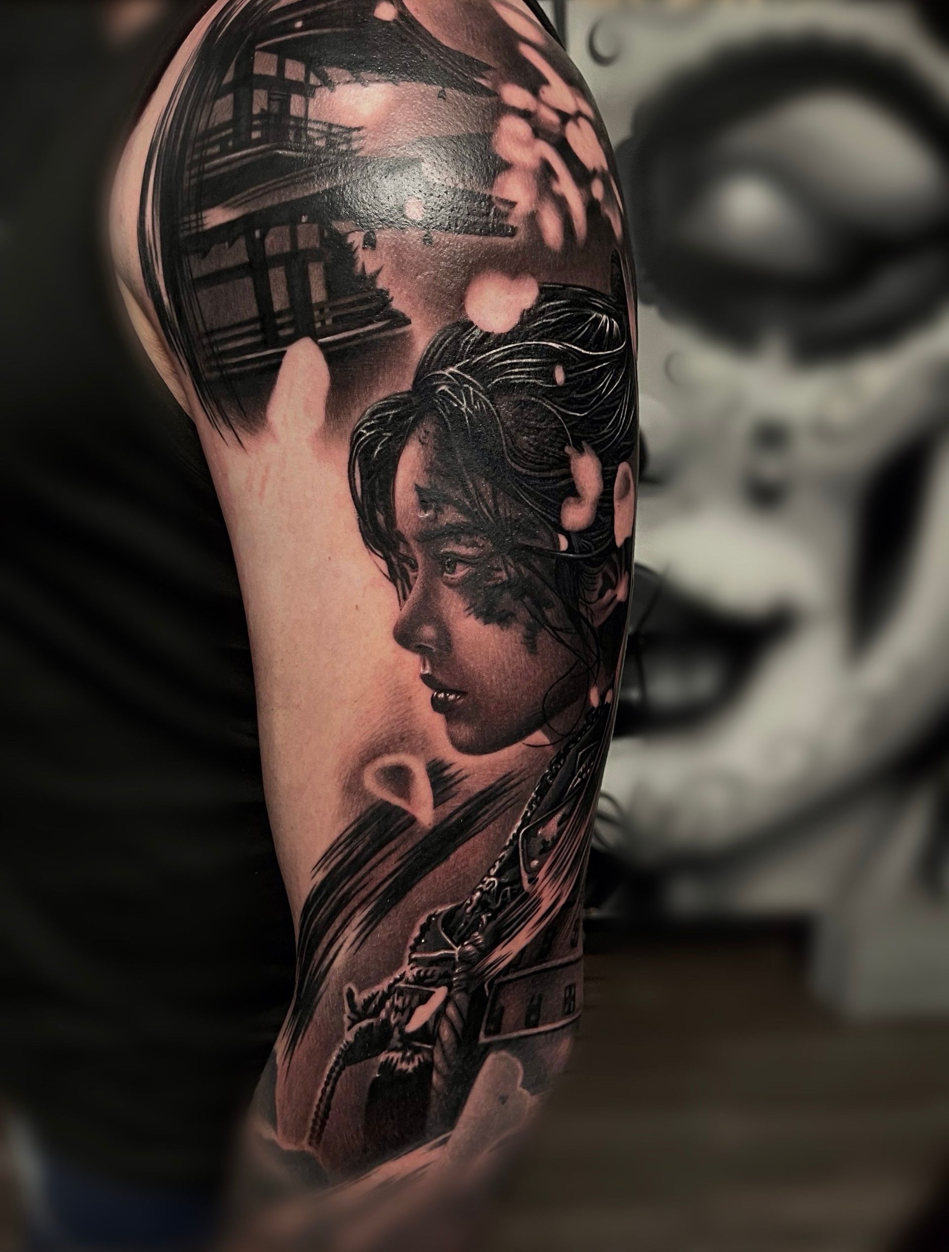 A black and white tattoo of a woman on a man 's arm.