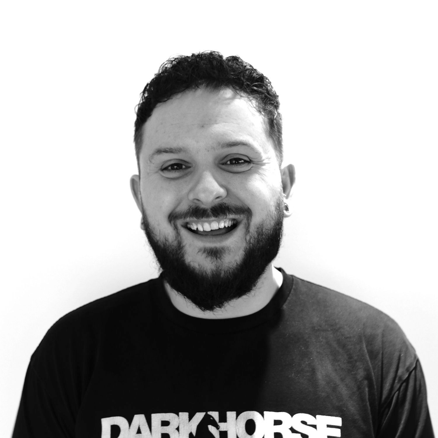 A man with a beard is wearing a dark horse shirt