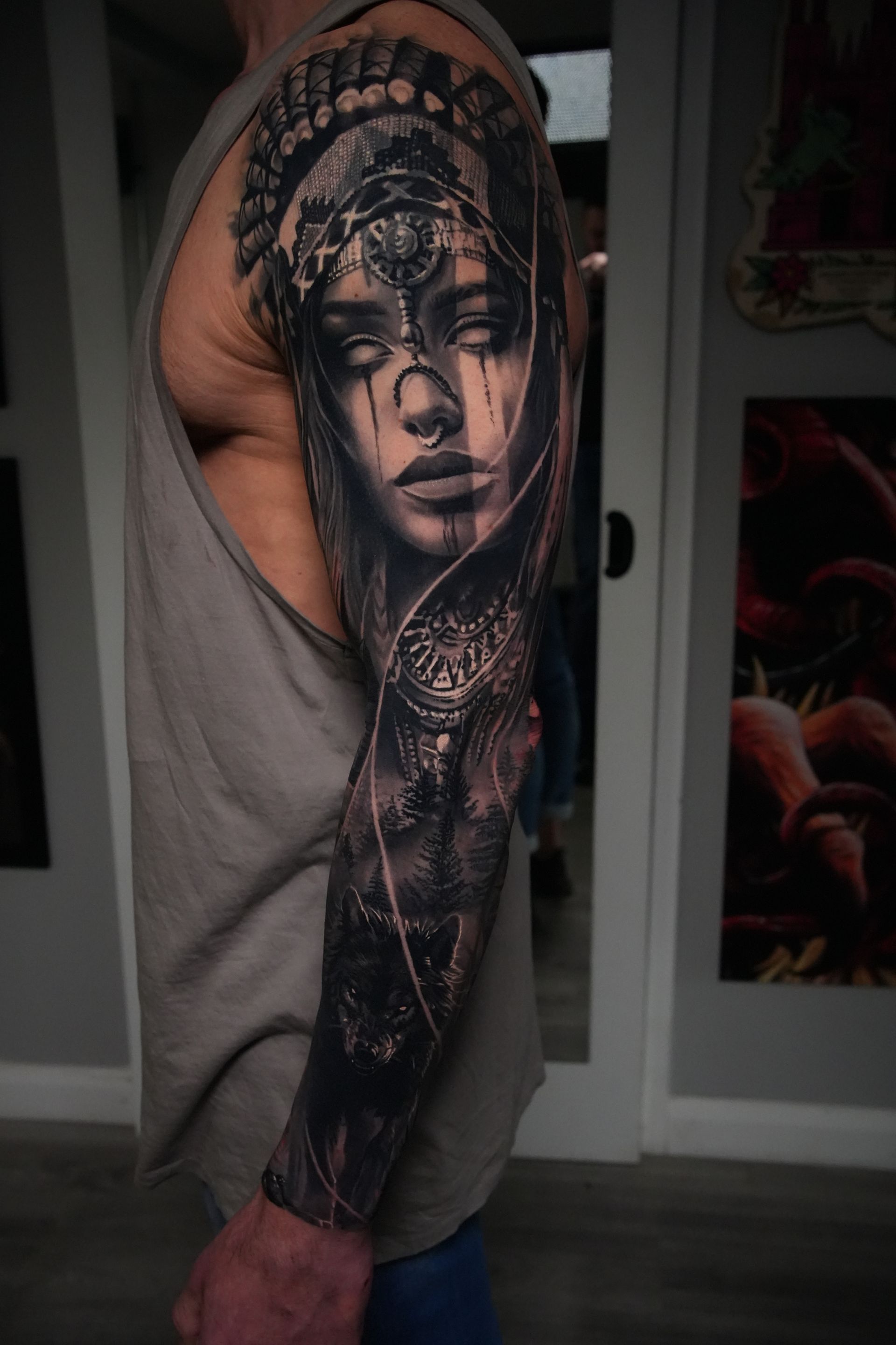 Sleeve tattoo of a woman's face with intricate details on an arm. Features black and white shading, realistic style.