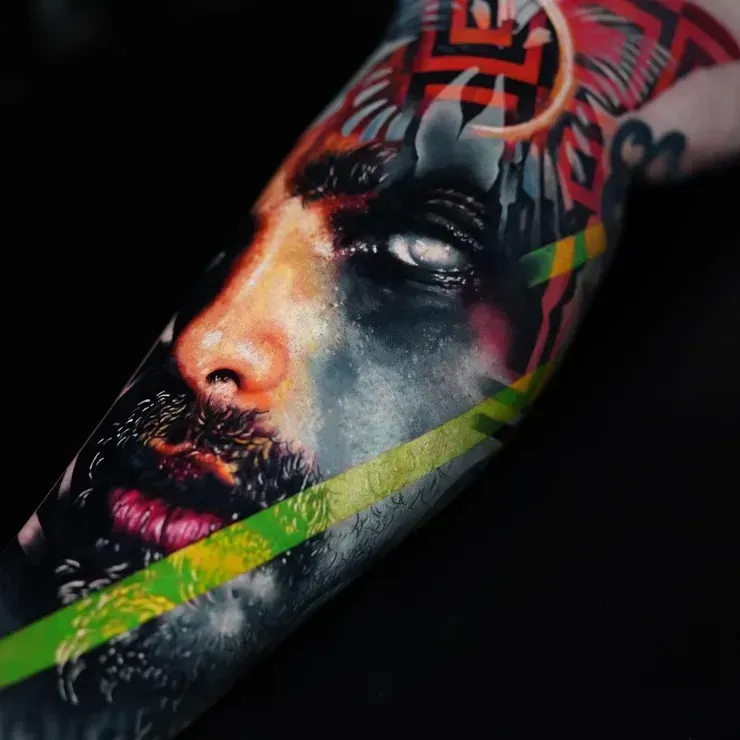 A close up of a tattoo of a man 's face on a person 's arm.