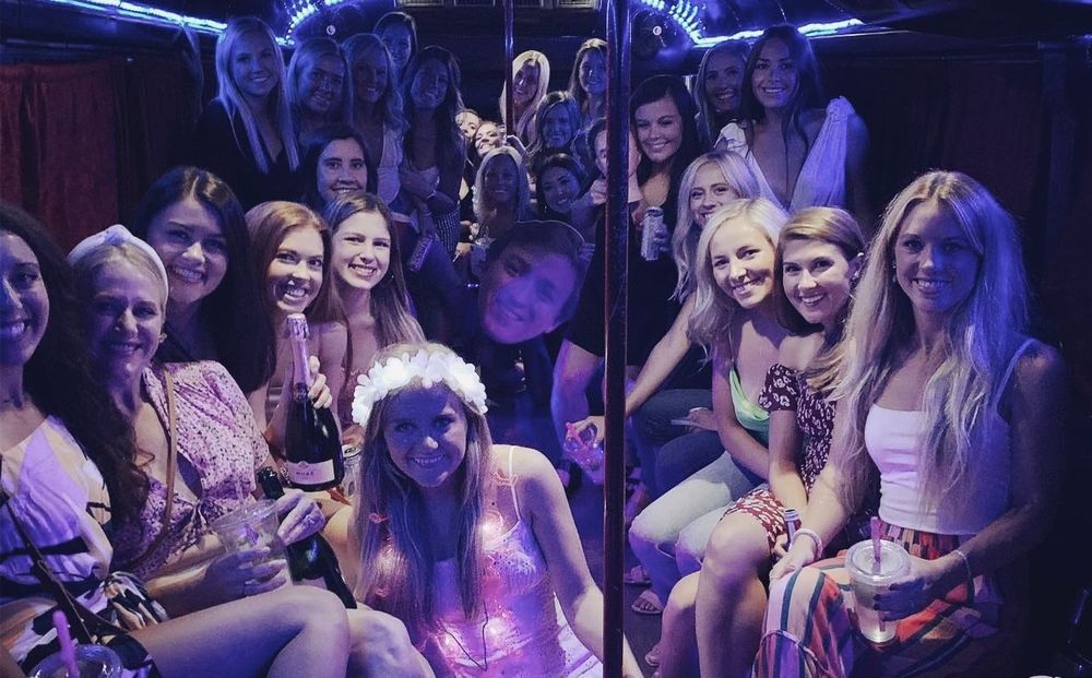 A group of women are posing for a picture on a party bus.